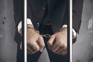 Concept of handcuffed businessman in jail